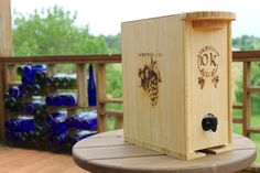 a wooden box sitting on top of a table next to blue glass bottles in the background