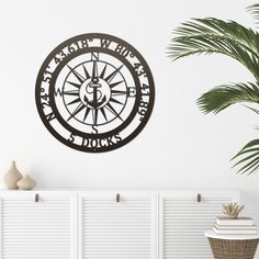 a clock on the wall in a living room with a potted plant next to it