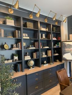 a room with many bookshelves and lamps on the wall next to each other