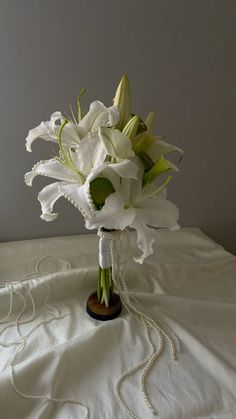 a bouquet of white flowers sitting on top of a bed