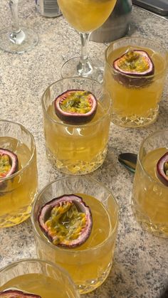 several glasses filled with drinks sitting on top of a counter