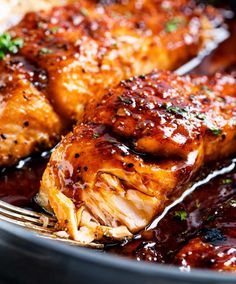 closeup of chicken wings with sauce and parsley on the side in a pan