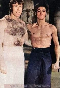 two men standing next to each other wearing towels