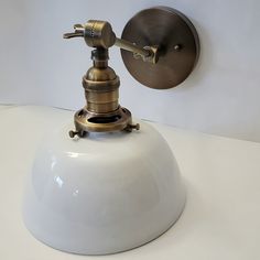 an old fashioned faucet mounted on the wall with a light bulb attached to it