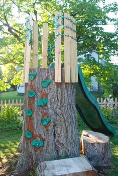 a tree stump with a slide in the back ground and some green buttons on it