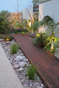 a wooden deck surrounded by plants and rocks