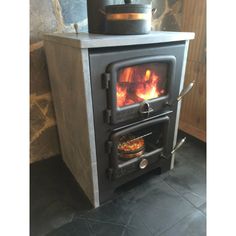 a stove with a pot on top of it next to a brick wall and floor