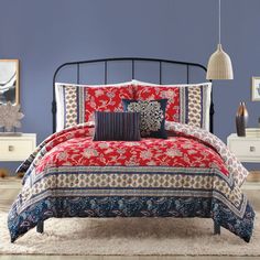 a bedroom with blue walls and red bedding