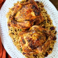 chicken and rice on a white plate with an orange napkin