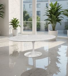 a white table sitting in the middle of a room with potted plants on either side