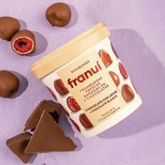 some chocolates and pieces of fruit on a purple surface with the word franu next to it