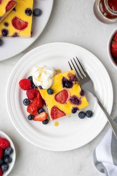 a slice of cheesecake topped with berries and whipped cream on top of a white plate