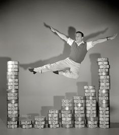 a man is jumping over stacks of coins with his arms out and legs in the air