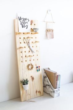 there is a wooden peg board with many magnets on it next to a book shelf