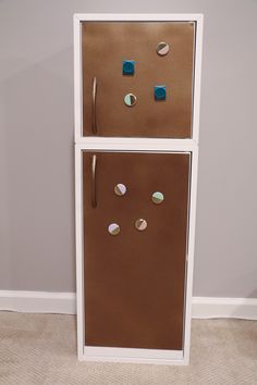 a refrigerator that is made out of cardboard with magnets on it