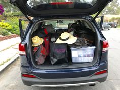 the back end of a car with hats and luggage in it's boot compartment