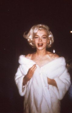 marilyn monroe wearing a white fur coat and posing for the camera