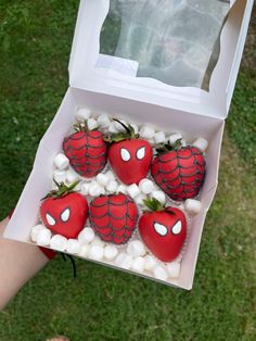 a box filled with strawberries and marshmallows in the shape of spider - man