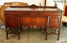 an antique desk with two chairs in the background