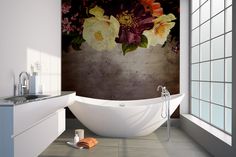 a bath tub sitting next to a sink in a bathroom under a painting on the wall