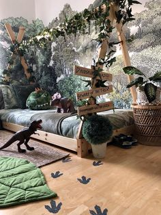 a bed room with a wooden floor and a wallpapered forest scene on the wall