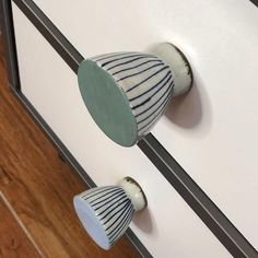 two blue and white knobs on a cabinet