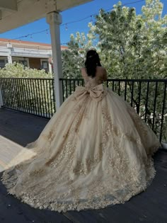 a woman in a ball gown is standing on a porch with her back to the camera