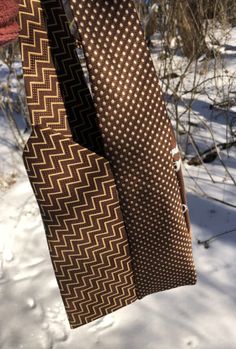 two ties hanging from a tree in the snow