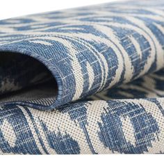 the blue and white fabric is folded on top of each other, with an intricate pattern