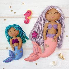 two little mermaid dolls sitting next to each other