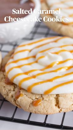 two cookies with white frosting and caramel drizzled on top, sitting on a cooling rack