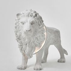 a white lion figurine with a collar around its neck, standing on a white background