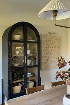 a dining room table and chairs in front of a glass door with an arched window