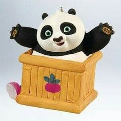 a small toy panda bear sitting in a wooden box with its arms out and eyes wide open