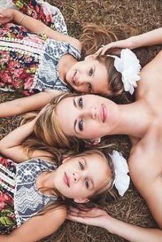 three beautiful young women laying on the ground in front of each other wearing matching dresses