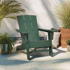 a green lawn chair sitting on top of a cement floor next to potted plants