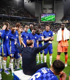 a group of soccer players standing on top of a field