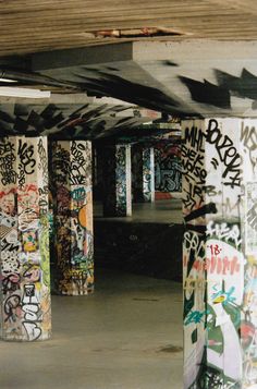 graffiti on the walls and ceiling of an abandoned parking garage with no doors or windows