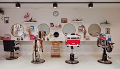 a room with three different types of hair dryers on pedestals and mirrors above them