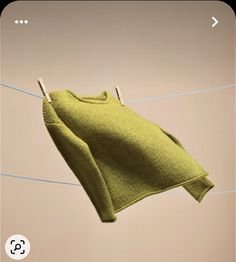 a green sweater hanging on a clothes line