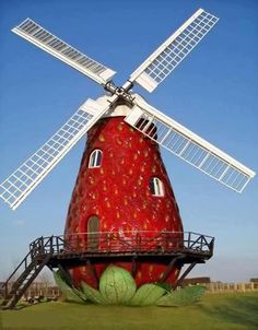 an old windmill sits in the middle of a grassy field with stairs leading up to it