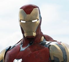 an iron man is standing in front of the sky with his hands on his hips