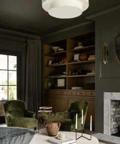 a living room filled with furniture and a fire place in front of a book shelf