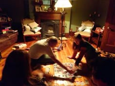 a group of people sitting on top of a wooden floor next to a fire place