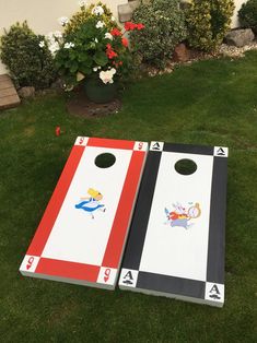 two cornhole game boards sitting in the grass