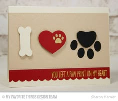 a card with two dogs paw prints and a heart