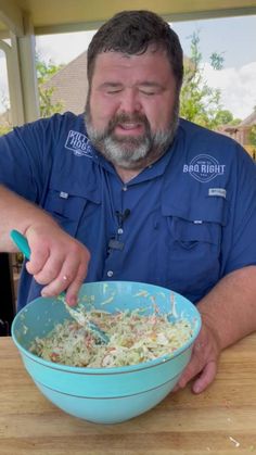 a man in blue shirt mixing food into a bowl