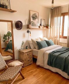 a bed room with a neatly made bed next to a chair and a large window