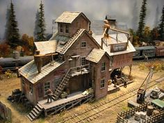 an image of a model train station with people on the roof and in the yard