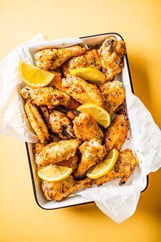 chicken wings with lemons and spices in a tray